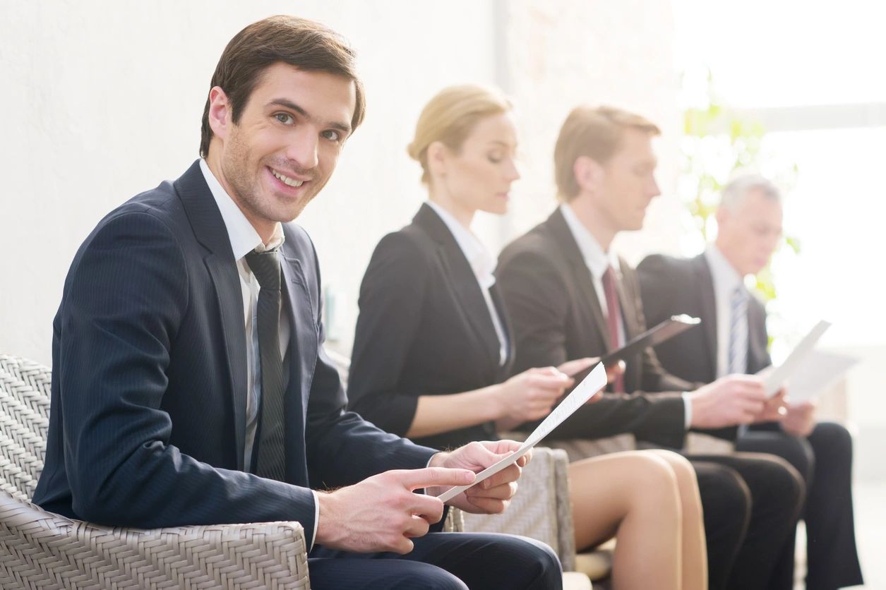 A group of people sitting in a row holding ipads.