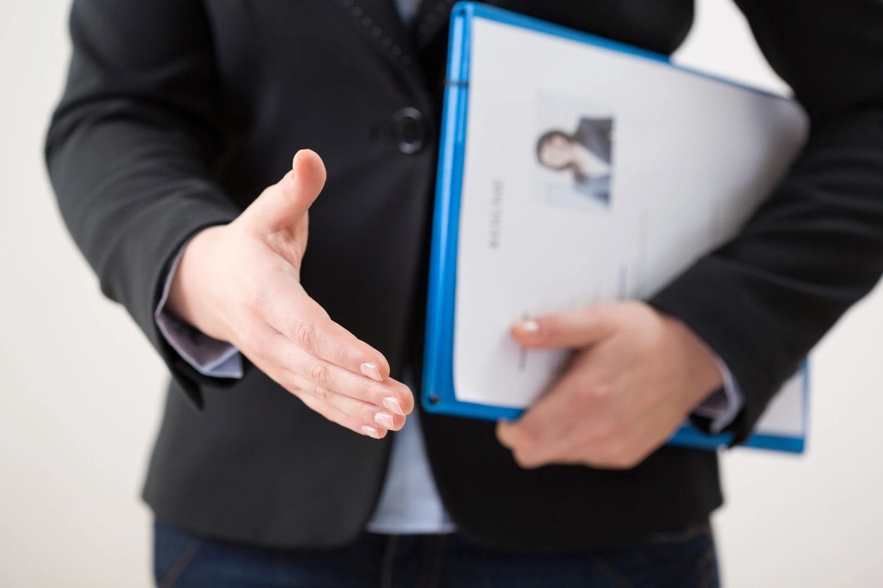 A person holding out their hand for someone to shake.