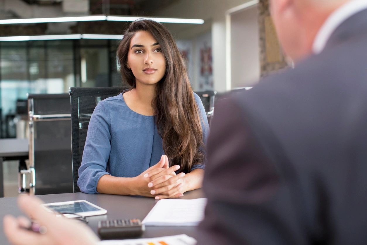 A woman sitting at a table with another person.